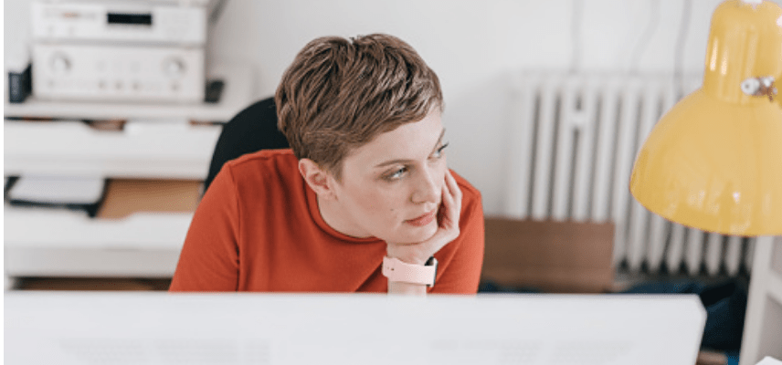 Woman sitting at desk in front of monitor