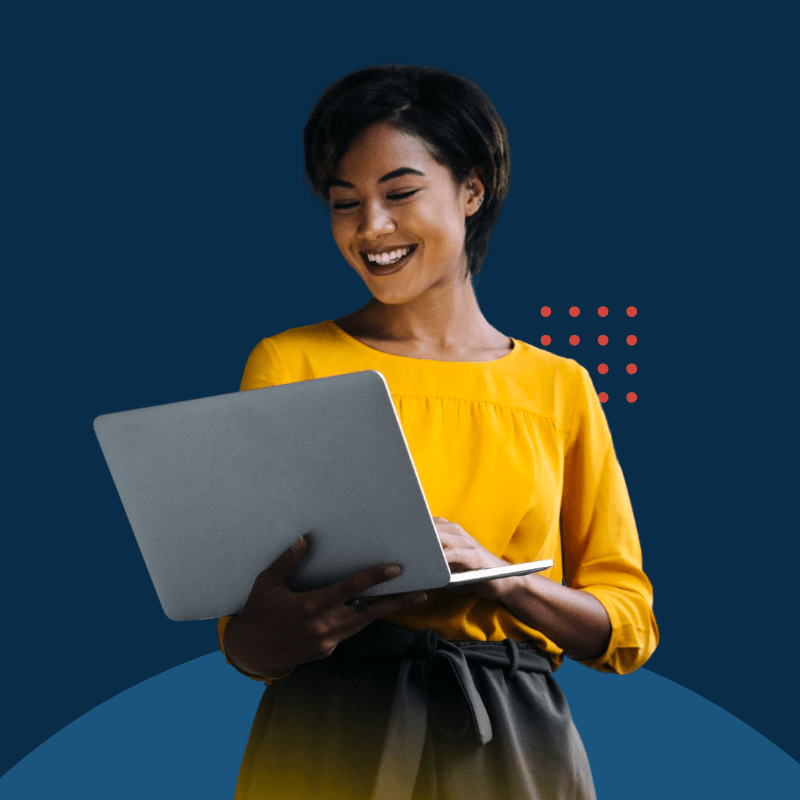 A black woman smiles while looking at the screen of a laptop that she's holding.